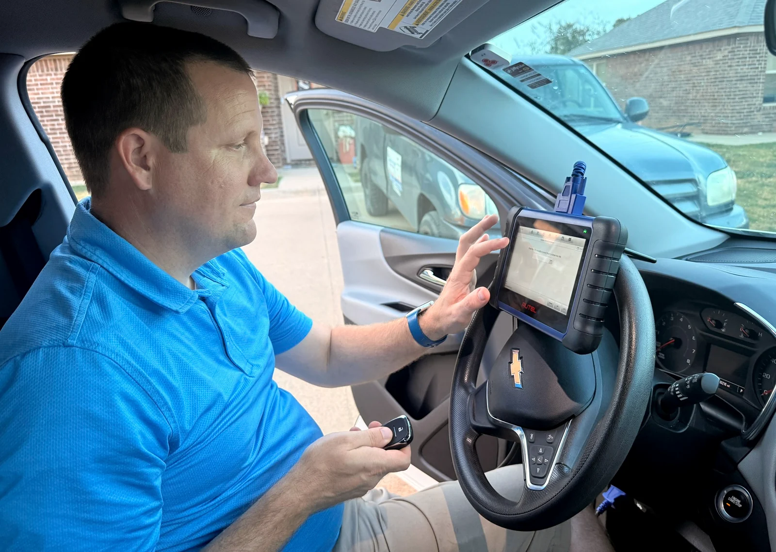 Justin holding a key fob while using a vehicle key programmer