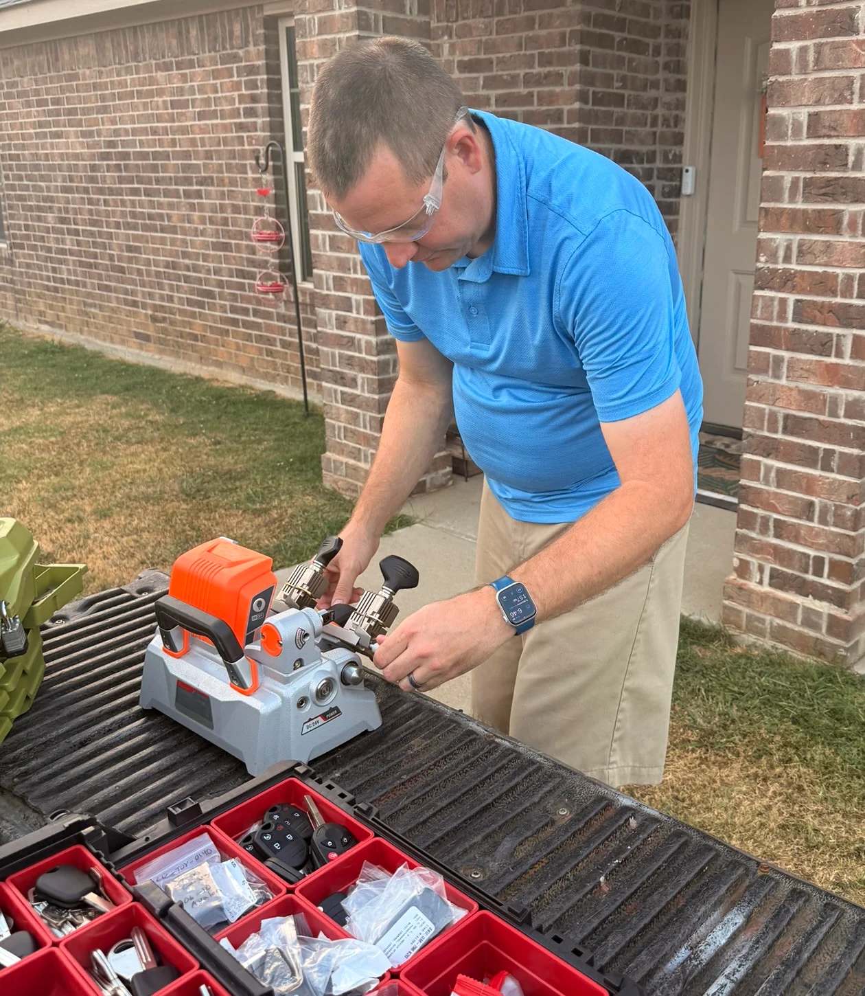 Justin cutting a key with a machine on his truck tailgate